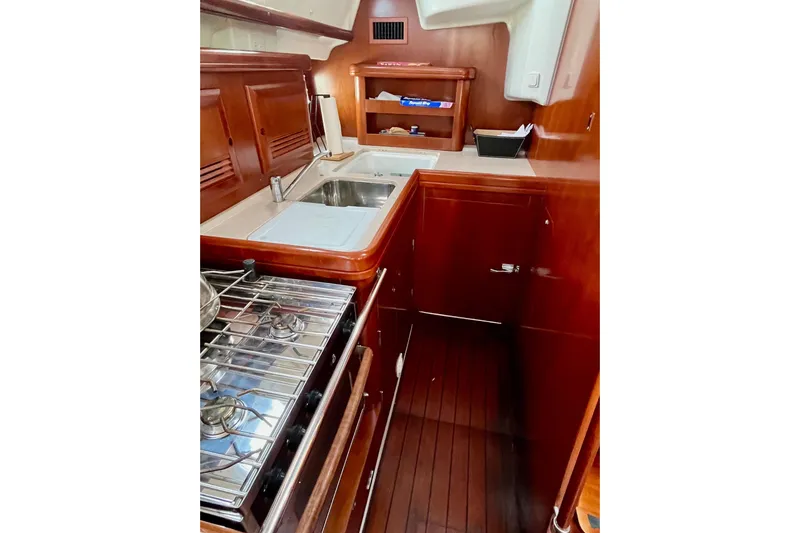 Sosy Yacht Photos Pics 2006 Beneteau Oceanis Clipper 423 yacht kitchen with wooden cabinetry and stainless steel appliances.