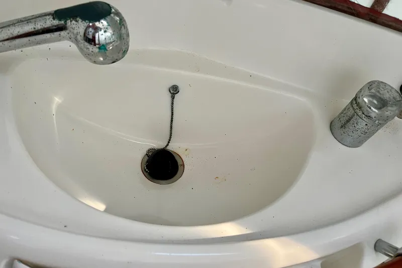 Sosy Yacht Photos Pics White sink with chrome faucet and plug chain, aboard 2006 Beneteau Oceanis Clipper 423 yacht.