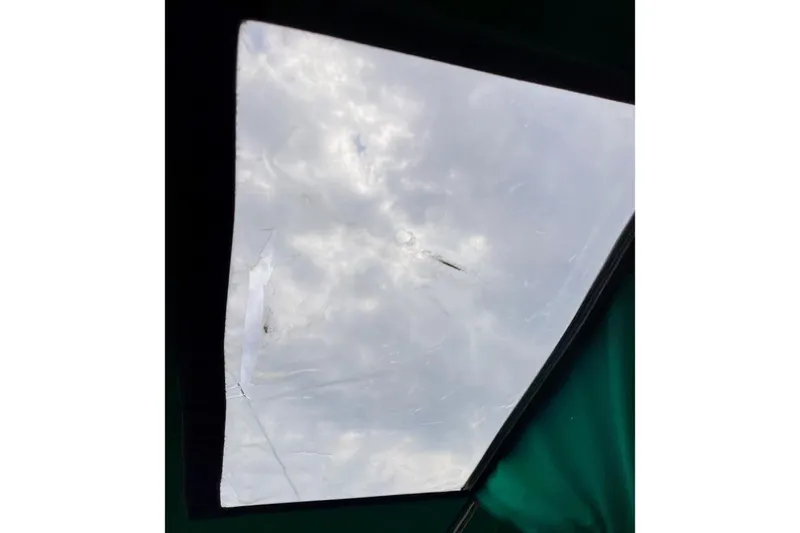 Sosy Yacht Photos Pics Cracked window on 2006 Beneteau Oceanis Clipper 423 sailboat, view of cloudy sky.