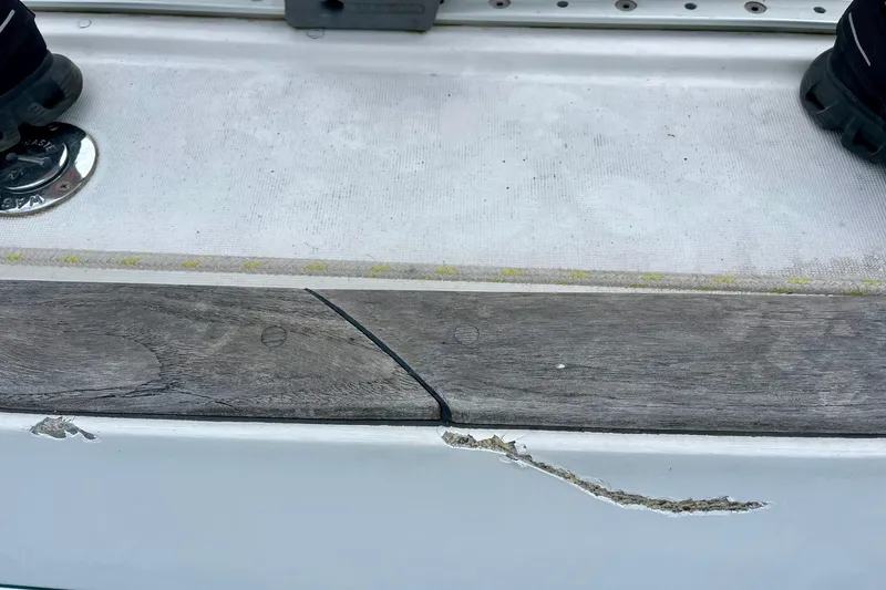 Sosy Yacht Photos Pics Damaged deck of 2006 Beneteau Oceanis Clipper 423 sailboat, showing cracked wood and fiberglass.