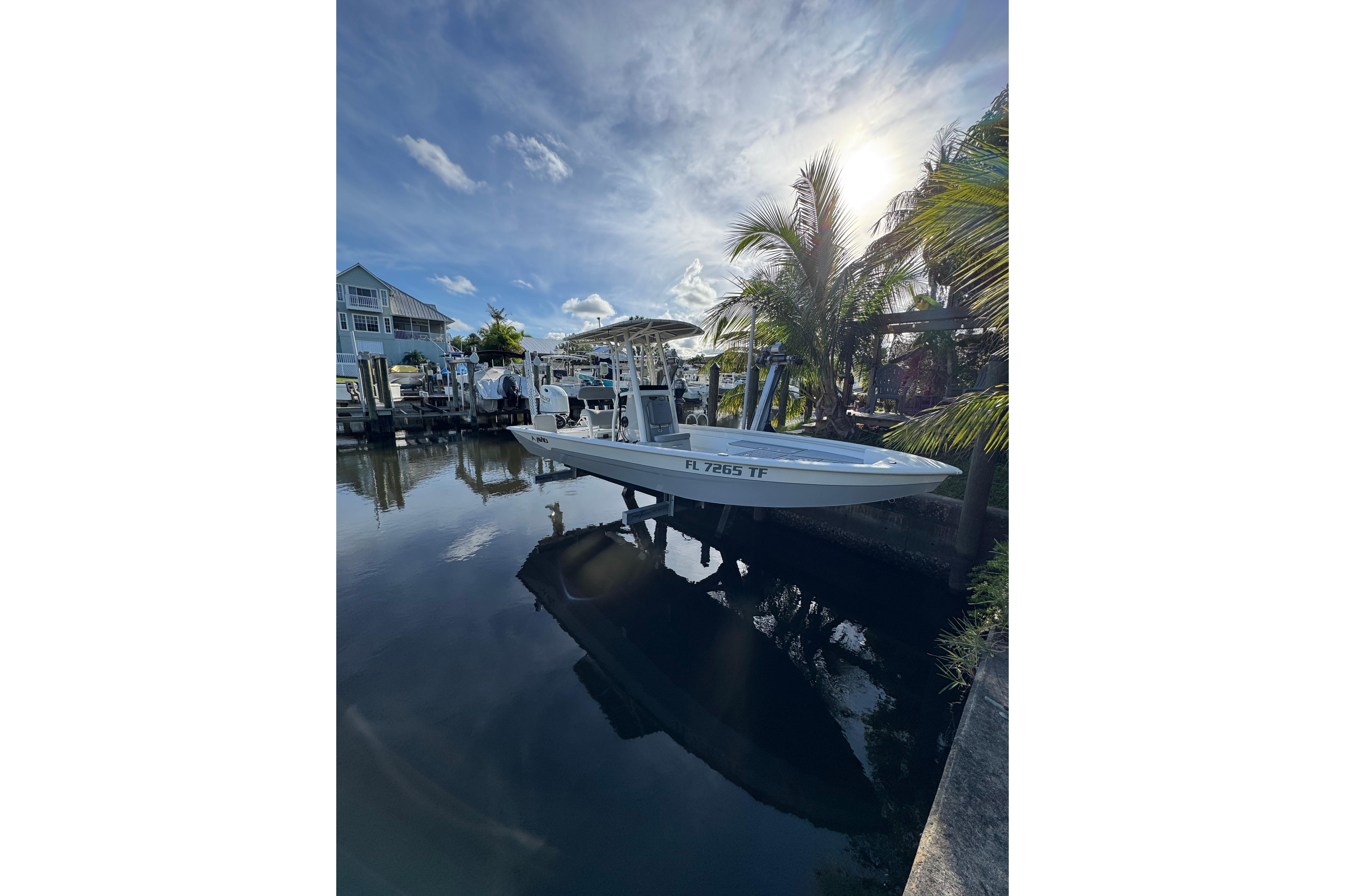 2022 Avid 23 FS Magnum boat docked by palm trees under a sunny sky.