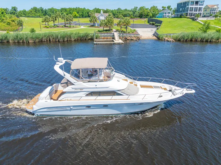  Yacht Photos Pics 1999 Sea Ray 450 Express Bridge yacht cruising on a scenic river.