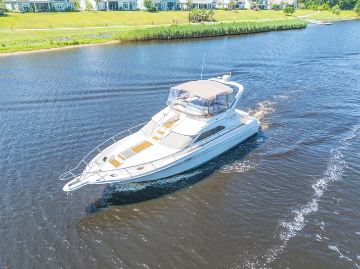  Yacht Photos Pics 1999 Sea Ray 450 Express Bridge cruising on a scenic river.
