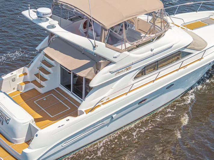  Yacht Photos Pics 1999 Sea Ray 450 Express Bridge yacht cruising on water, featuring spacious deck and elegant design.