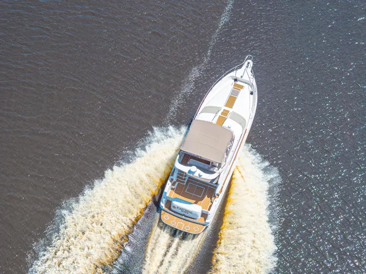  Yacht Photos Pics Aerial view of 1999 Sea Ray 450 Express Bridge cruising on water.