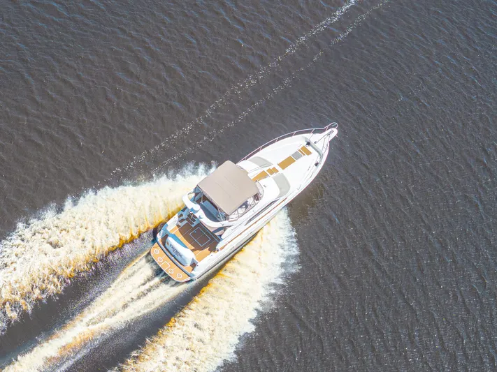  Yacht Photos Pics Aerial view of 1999 Sea Ray 450 Express Bridge cruising on open water.