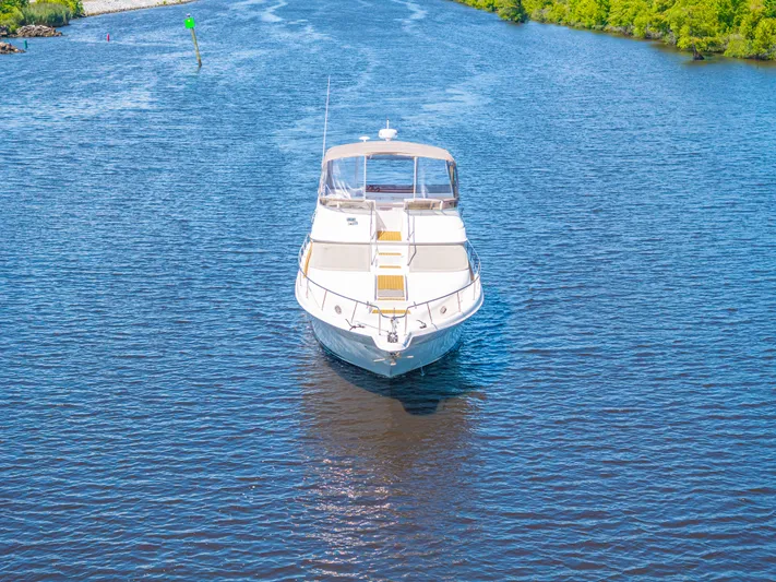  Yacht Photos Pics 1999 Sea Ray 450 Express Bridge yacht cruising on a serene river.