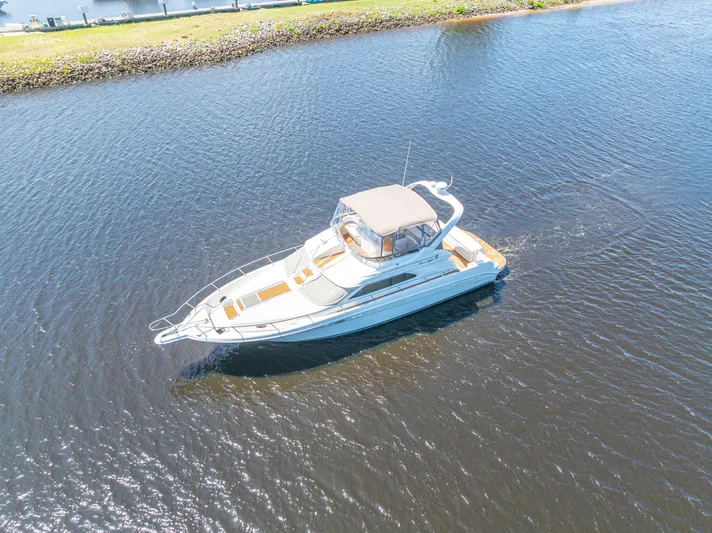  Yacht Photos Pics 1999 Sea Ray 450 Express Bridge yacht cruising on calm waters.