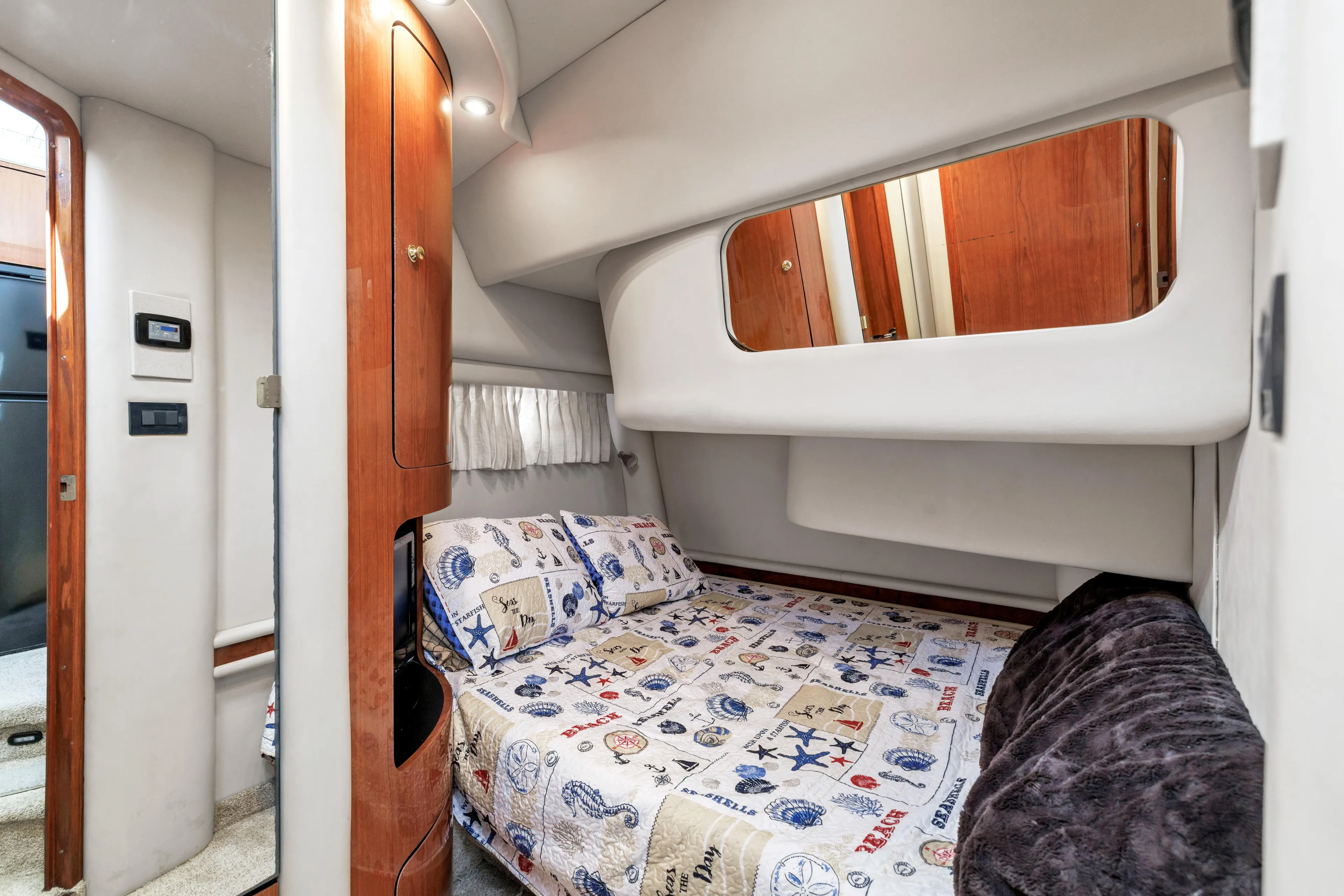  Yacht Photos Pics 1999 Sea Ray 450 Express Bridge cabin with nautical-themed bedding and wooden accents.