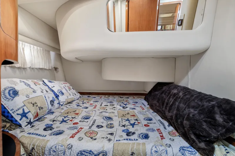  Yacht Photos Pics Cozy cabin interior of 1999 Sea Ray 450 Express Bridge with nautical-themed bedding.