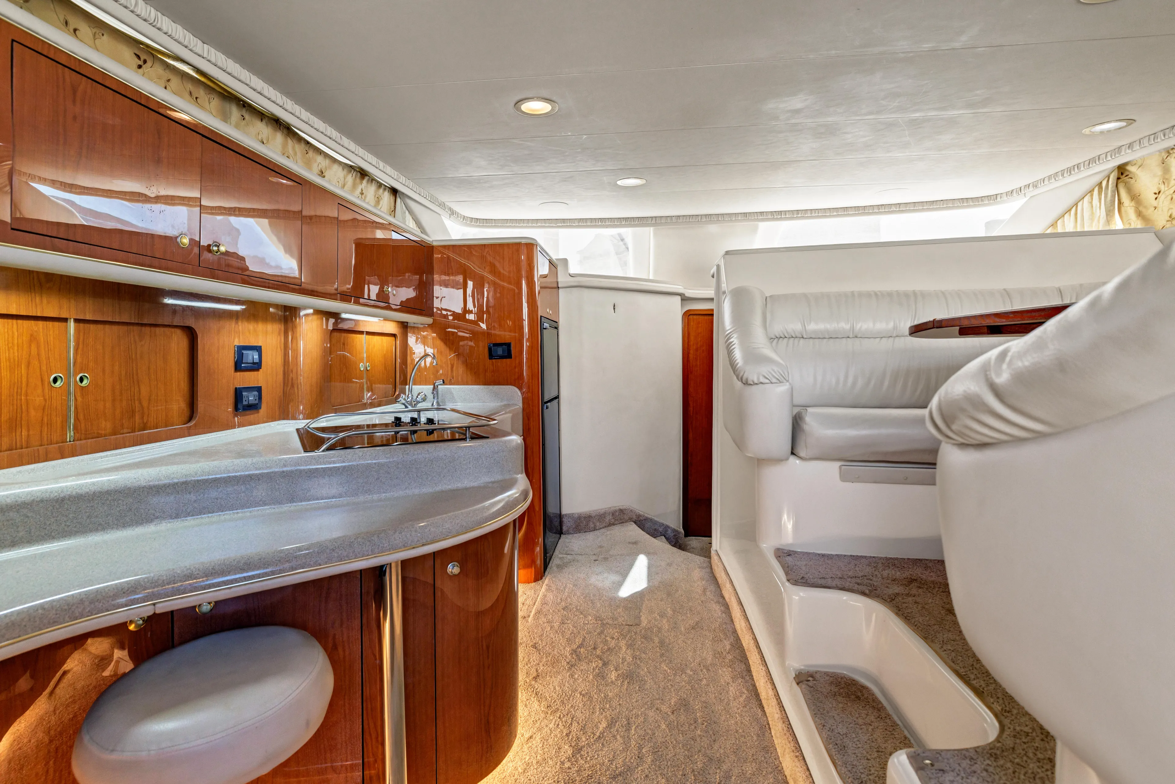  Yacht Photos Pics Luxurious interior of 1999 Sea Ray 450 Express Bridge yacht with modern kitchen and seating area.