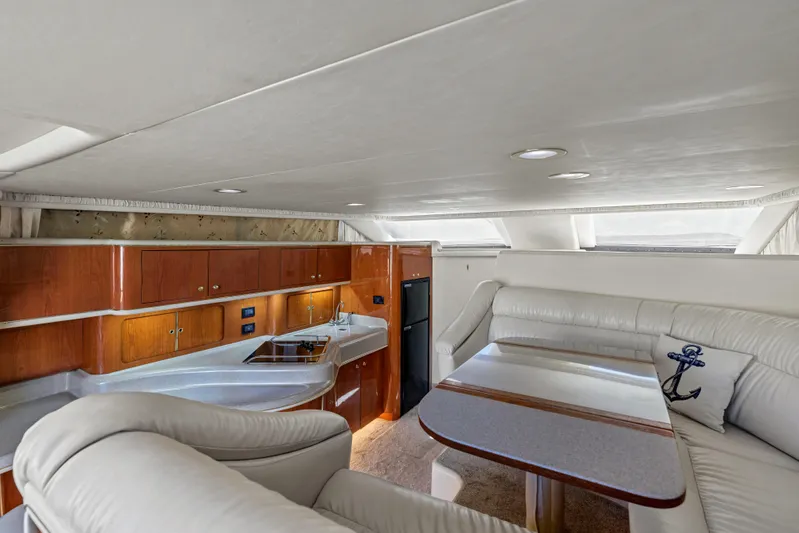  Yacht Photos Pics Luxurious interior of 1999 Sea Ray 450 Express Bridge yacht with elegant seating and kitchen area.