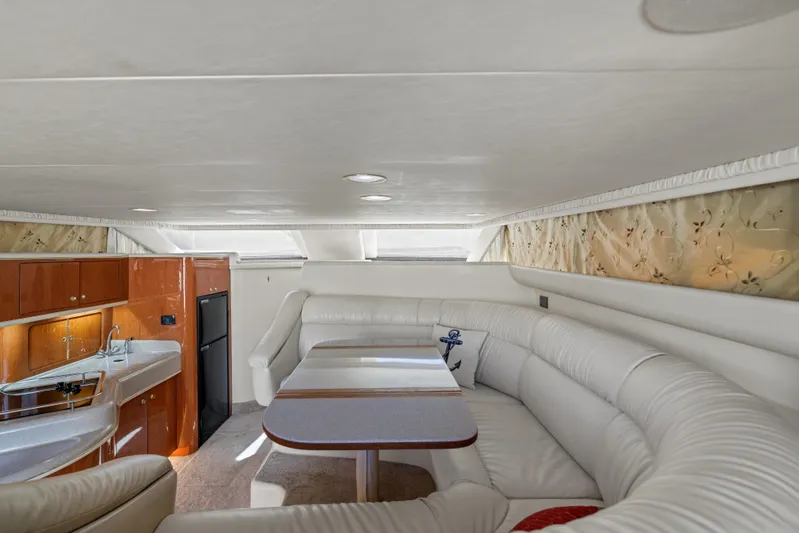  Yacht Photos Pics Luxurious interior of 1999 Sea Ray 450 Express Bridge with plush seating and kitchenette.