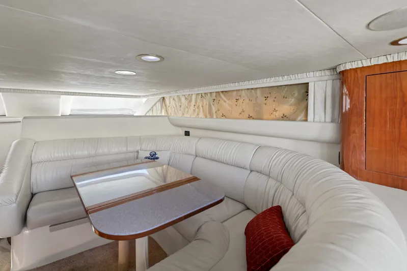  Yacht Photos Pics Luxurious interior of 1999 Sea Ray 450 Express Bridge with plush seating and elegant table.