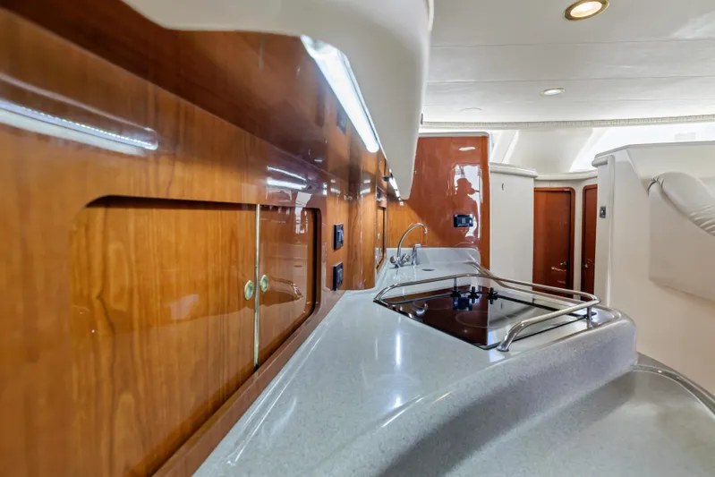 Yacht Photos Pics 1999 Sea Ray 450 Express Bridge interior with sleek kitchen and wooden cabinetry.