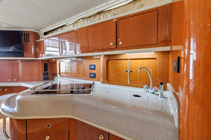  Yacht Photos Pics Luxurious kitchen interior of 1999 Sea Ray 450 Express Bridge yacht with wood cabinetry.