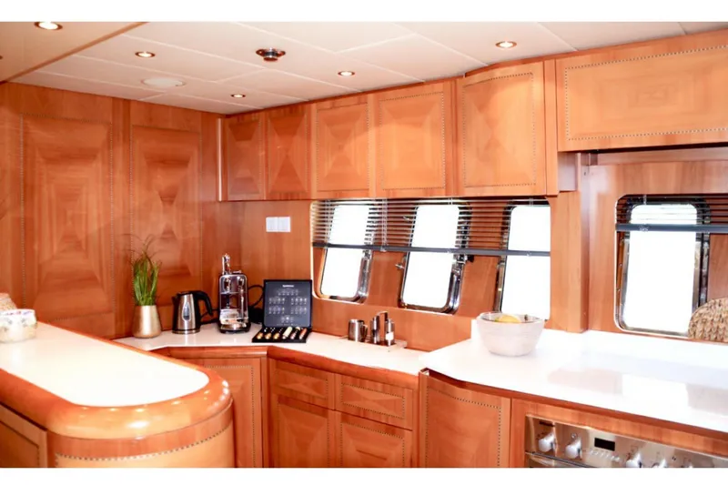  Yacht Photos Pics Luxurious 2003 Mangusta 72 yacht kitchen with wood cabinetry and modern appliances.