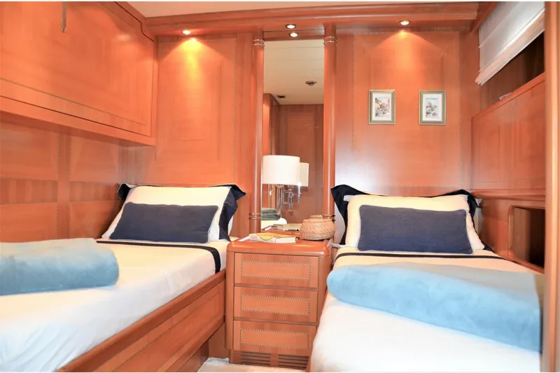  Yacht Photos Pics Luxurious twin cabin interior on 2003 Mangusta 72 yacht, featuring elegant wood paneling and cozy bedding.