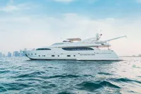 Luxurious 2007 Custom Line 112 yacht cruising on open water with city skyline backdrop.