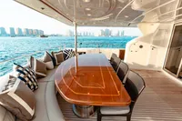 Luxurious yacht deck with elegant dining area, Custom Line 112, 2007 model, overlooking serene waterfront.