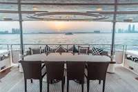 Luxury yacht deck with dining area, sunset view over water, Custom Line 112, 2007 model.