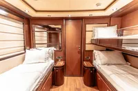 Luxurious 2007 Custom Line 112 yacht cabin with twin beds and elegant wood finish.