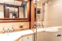 Luxurious yacht bathroom with wooden accents, glass shower, and modern fixtures, Custom Line 112, 2007.