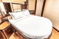 Luxurious bedroom interior on 2007 Custom Line 112 yacht, featuring elegant wood finishes.