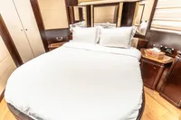 Luxurious bedroom interior on a 2007 Custom Line 112 yacht, featuring elegant wood finishes.