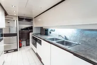 Modern yacht kitchen with dual sinks, stainless steel appliances, and sleek cabinetry, Custom Line 112, 2007.