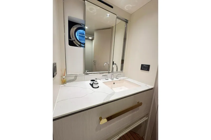  Yacht Photos Pics Luxurious bathroom vanity on 2022 Azimut Fly 78 yacht, featuring elegant fixtures and a porthole window.