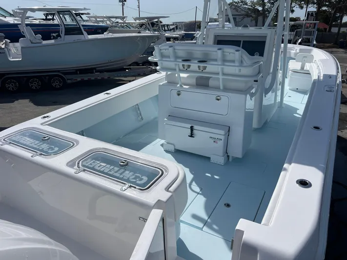 Yacht Photos Pics 2025 Contender 30 ST boat interior with seating and storage, docked alongside other boats.