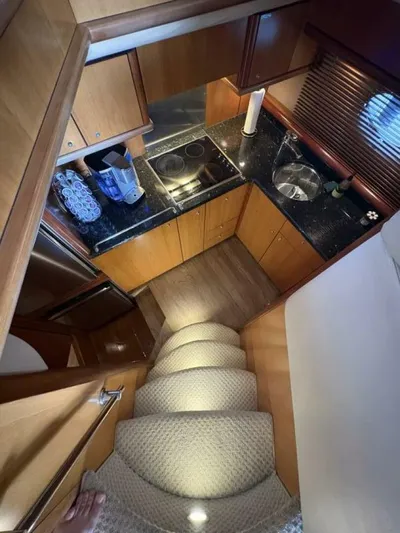 Prelude Yacht Photos Pics Compact kitchen in 2004 Sunseeker Manhattan 56 yacht with wooden cabinets and black countertops.