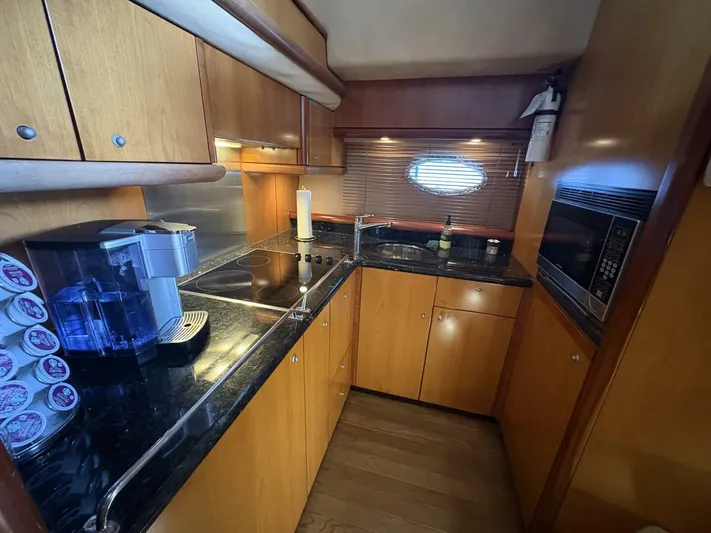 Prelude Yacht Photos Pics Luxurious 2004 Sunseeker Manhattan 56 yacht kitchen with modern appliances and sleek wood cabinetry.