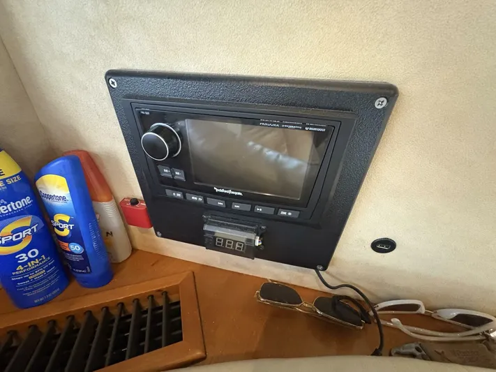 Prelude Yacht Photos Pics Control panel on 2004 Sunseeker Manhattan 56 yacht, with sunscreen bottles and sunglasses nearby.