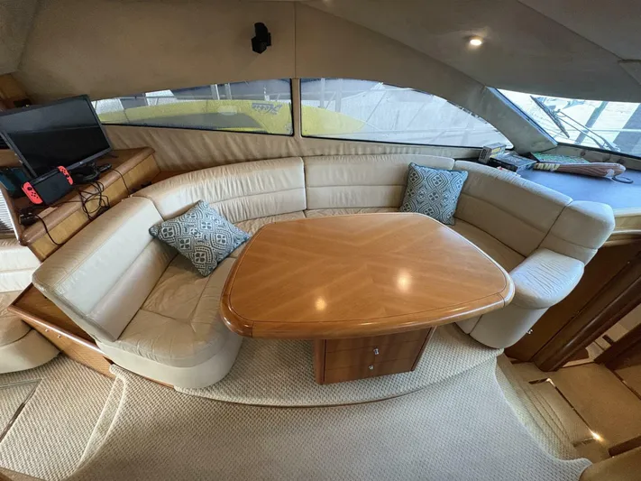Prelude Yacht Photos Pics Luxurious interior of 2004 Sunseeker Manhattan 56 yacht with plush seating and wooden table.