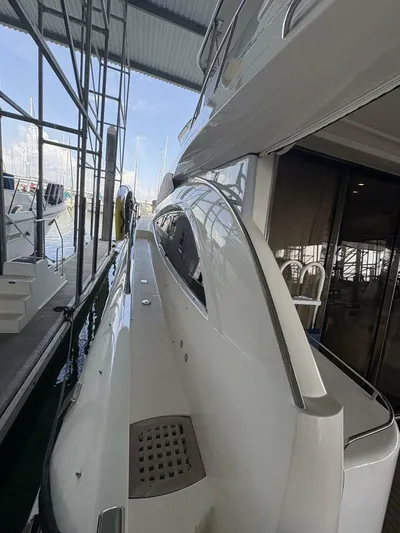 Prelude Yacht Photos Pics 2004 Sunseeker Manhattan 56 yacht docked in a marina under a covered structure.