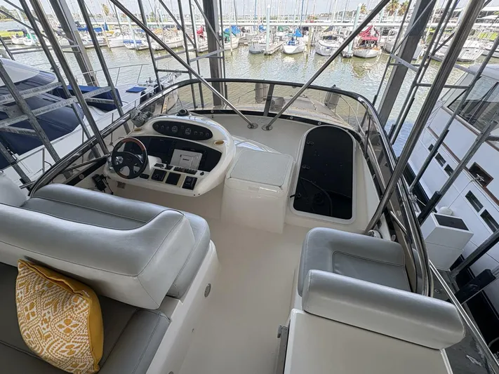 Prelude Yacht Photos Pics 2004 Sunseeker Manhattan 56 yacht helm with marina view, featuring modern controls and seating.