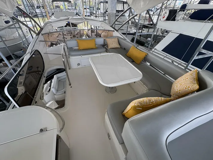 Prelude Yacht Photos Pics 2004 Sunseeker Manhattan 56 yacht interior with seating and table, featuring yellow cushions.