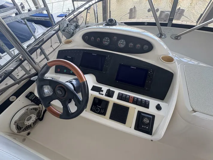 Prelude Yacht Photos Pics Control panel of a 2004 Sunseeker Manhattan 56 yacht with steering wheel and navigation instruments.