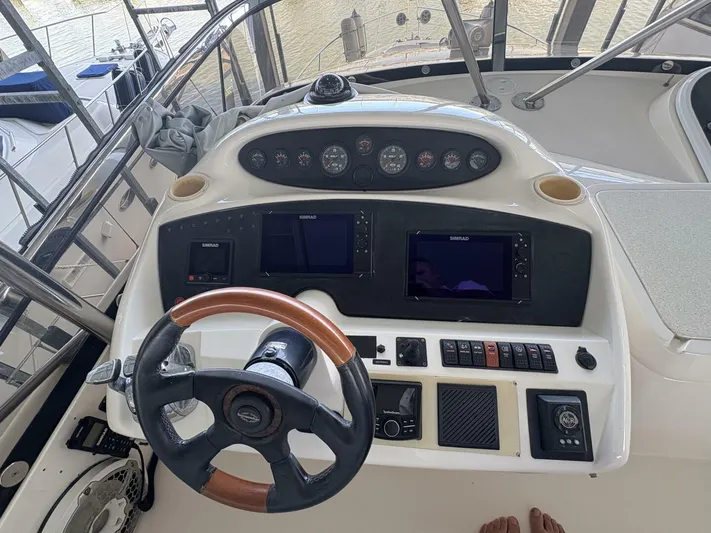 Prelude Yacht Photos Pics Control panel of a 2004 Sunseeker Manhattan 56 yacht with steering wheel and navigation displays.