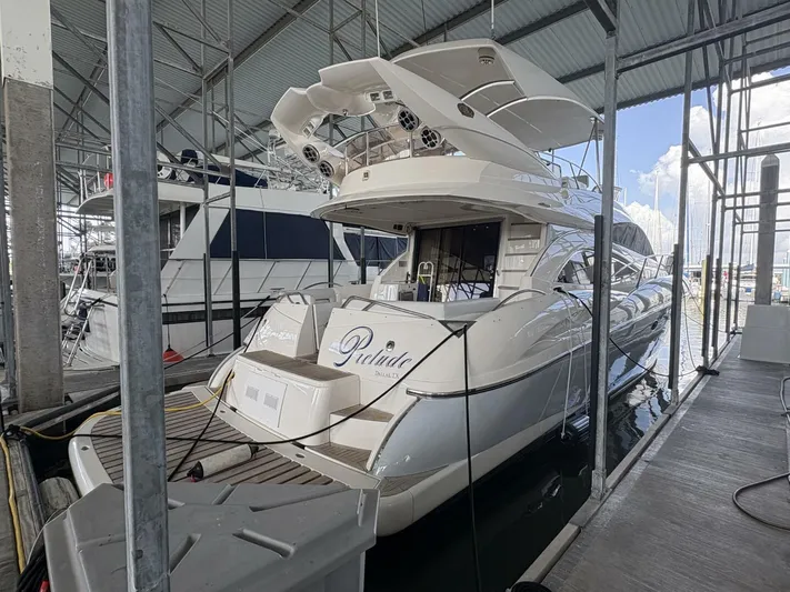 Prelude Yacht Photos Pics 2004 Sunseeker Manhattan 56 yacht docked in a marina under a covered structure.