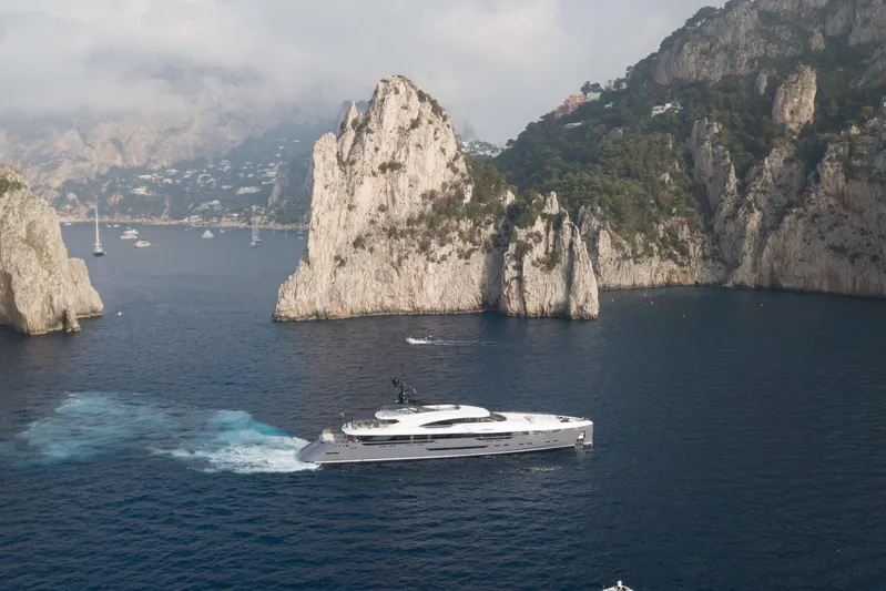 Utopia IV Yacht Photos Pics Luxurious 2018 Rossinavi Custom yacht cruising near stunning rocky cliffs.