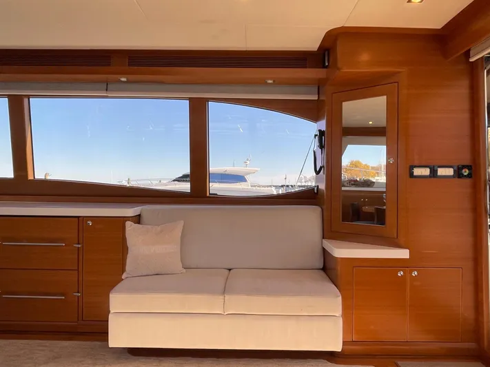 Resiliensea Yacht Photos Pics Interior of 2014 Nordhavn 60 Toro Convertible yacht with wooden cabinetry and beige sofa.