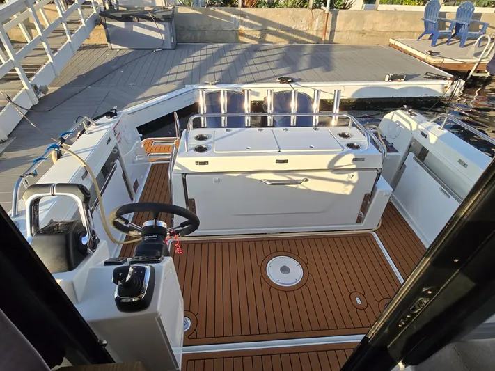 Down Time Yacht Photos Pics 2020 Jeanneau NC Sport 895 boat interior with teak flooring and modern helm.