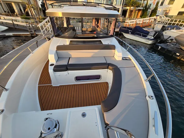 Down Time Yacht Photos Pics 2020 Jeanneau NC Sport 895 boat with spacious deck and seating area in marina.
