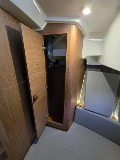 Down Time Yacht Photos Pics 2020 Jeanneau NC Sport 895 interior cabin with open wooden closet.