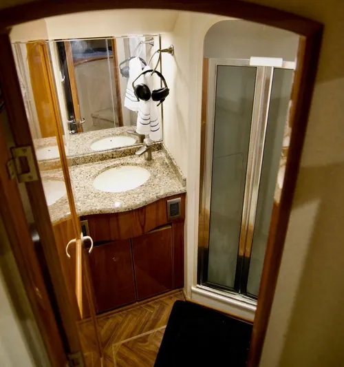 Serenity Now Yacht Photos Pics Luxurious bathroom in 2014 Viking 66 Convertible yacht with granite countertops and modern shower.