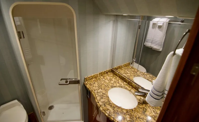 Serenity Now Yacht Photos Pics Luxurious bathroom in 2014 Viking 66 Convertible yacht with granite countertop and shower.