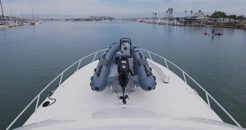 Serenity Now Yacht Photos Pics Bow view of 2014 Viking 66 Convertible yacht with inflatable boat, in a calm marina setting.